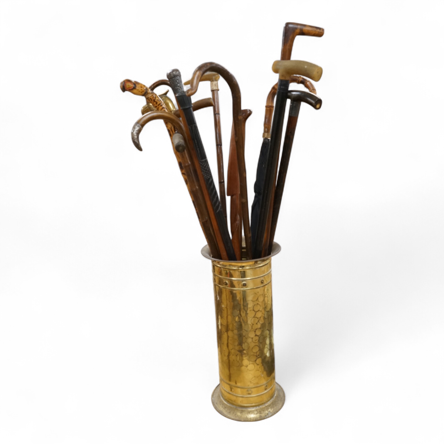 A collection of various walking sticks, some silver mounted, an umbrella with bamboo handle and a brass stick stand, stick stand 45cm high